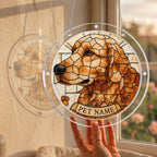 Hand holding the golden mosaic dog memorial puzzle suncatcher up to a sunlit window