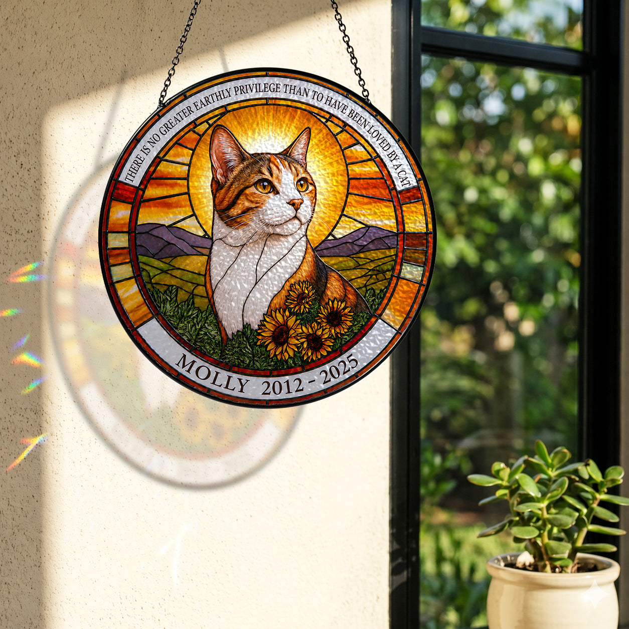 Cat memorial suncatcher casting colorful light by a sunny window