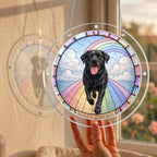 Black Labrador memorial puzzle suncatcher held up to a sunlit window by hand
