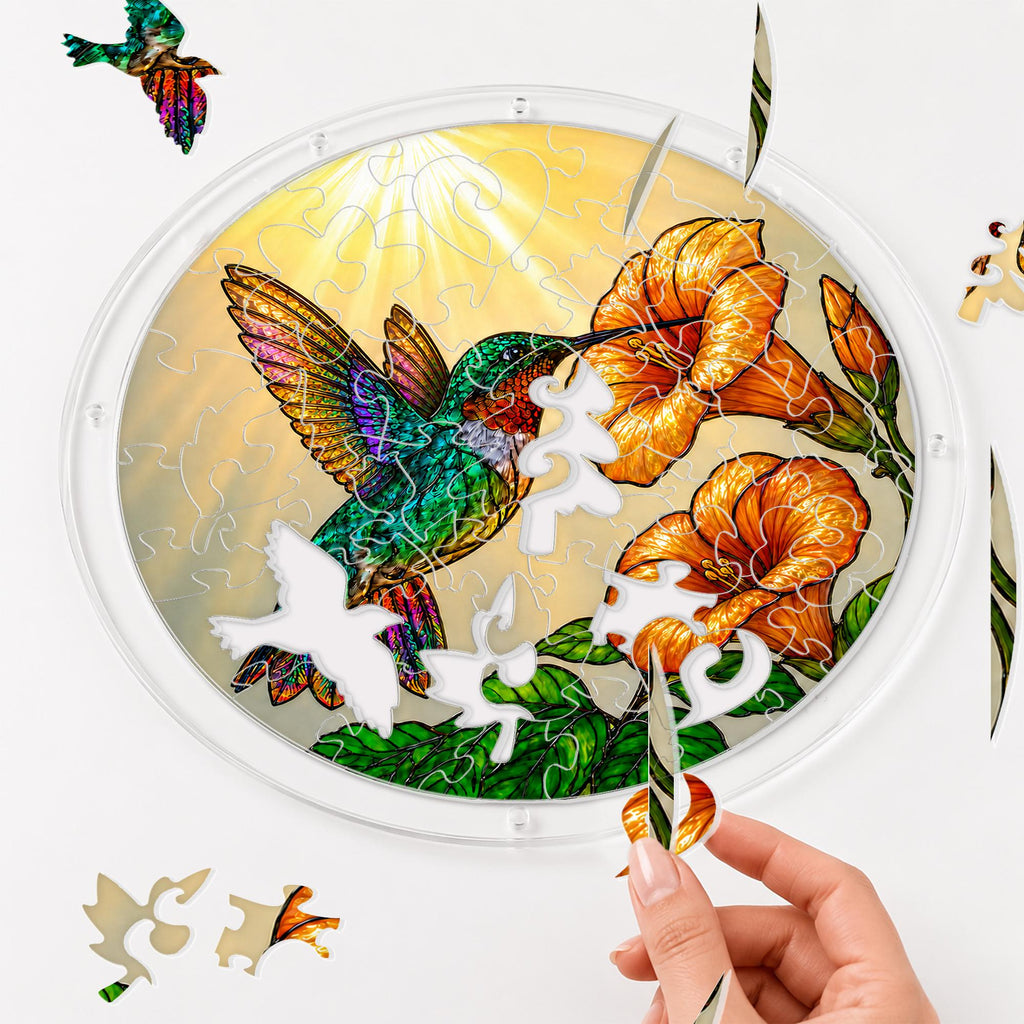 Hands assembling the hummingbird trumpet-flower puzzle suncatcher puzzle pieces