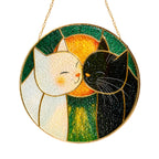 Cuddling cats stained glass suncatcher glowing with sunlight through the glass