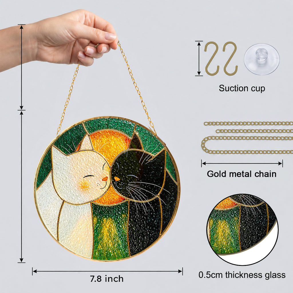 Cuddling cats stained glass suncatcher hanging in a sunlit window