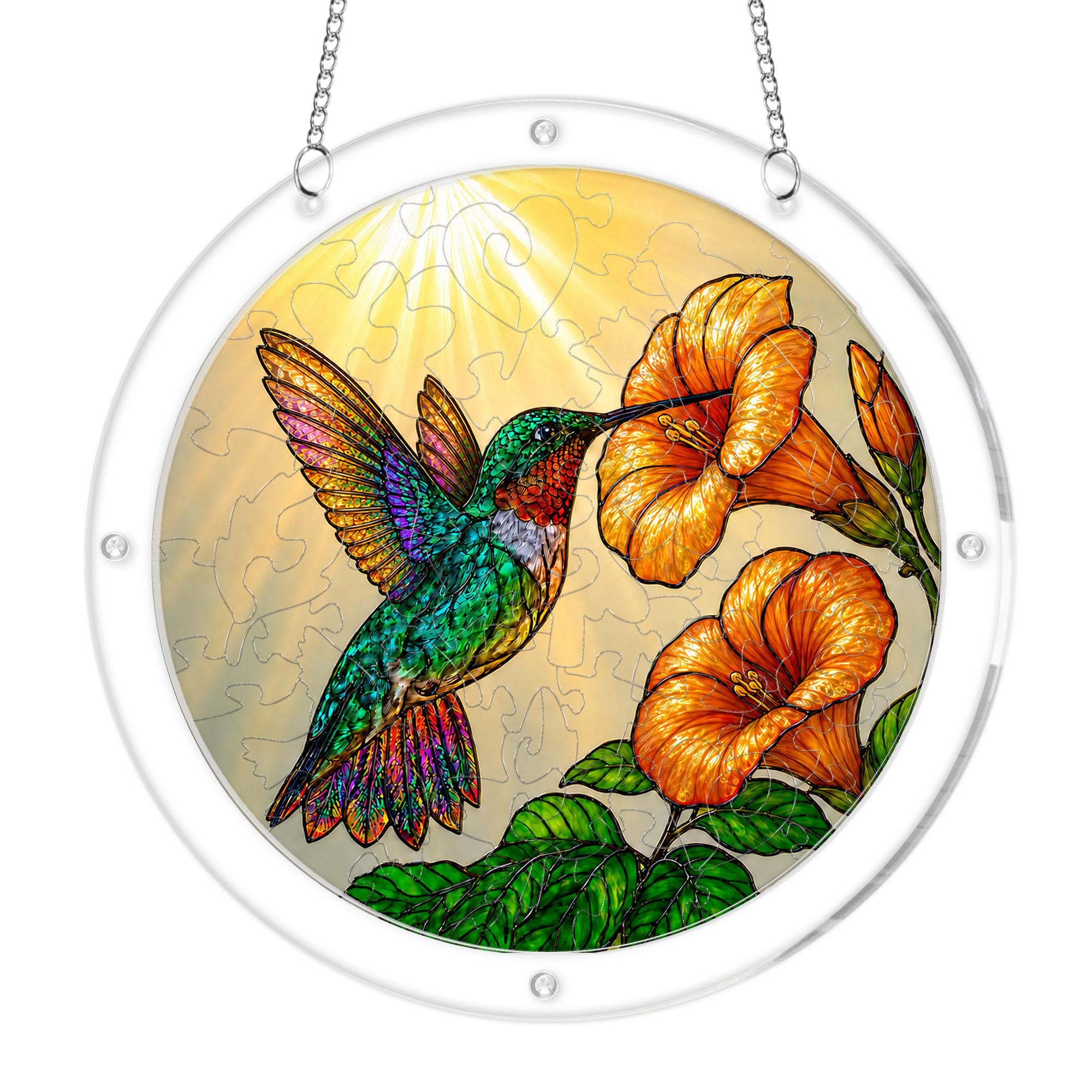 Hummingbird trumpet-flower puzzle suncatcher on its hanging chain against a white background