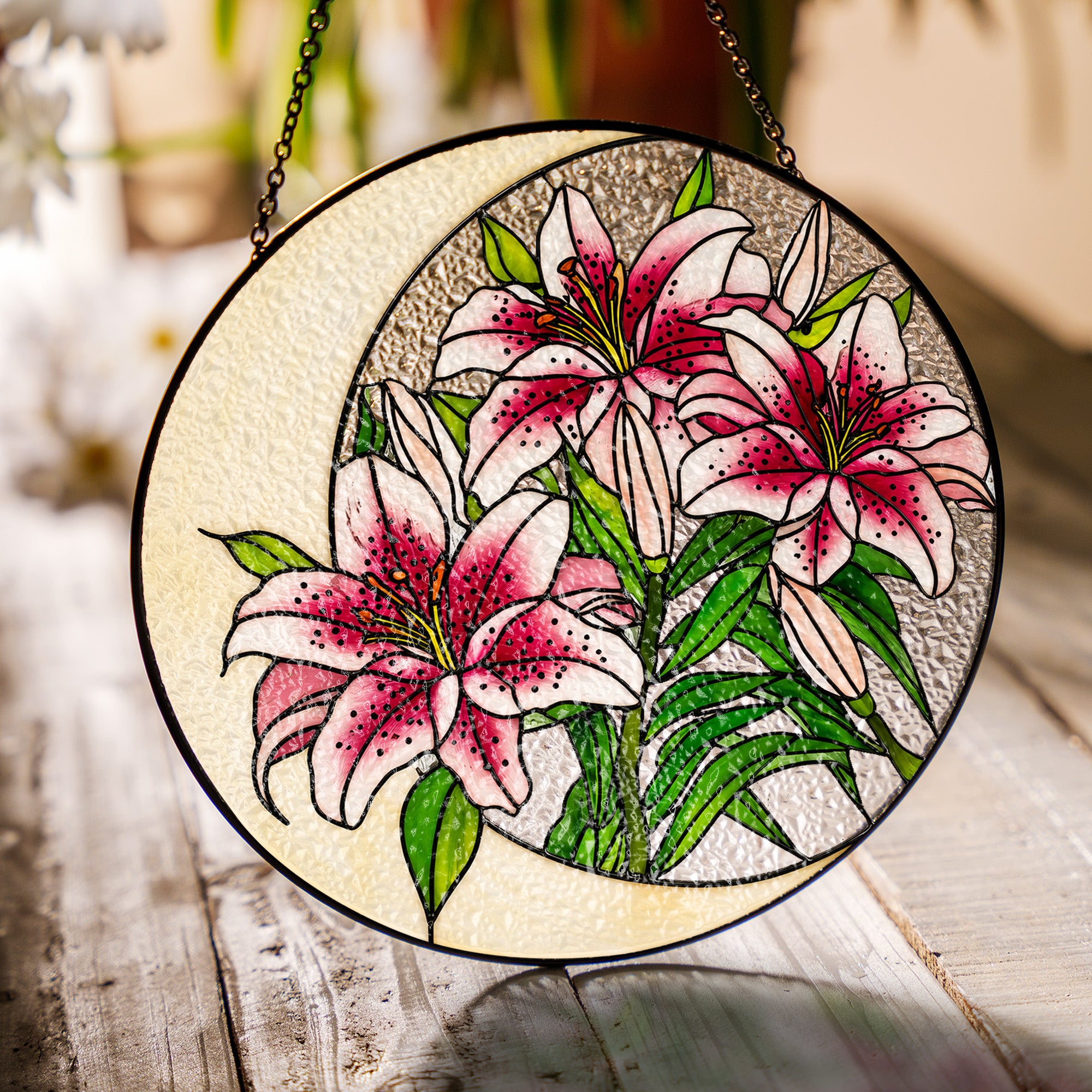 Pink lily stained glass suncatcher in a bright window with soft daylight