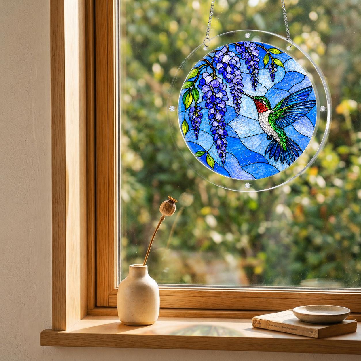Round hummingbird and purple flower suncatcher hanging in a cozy window with soft sunlight