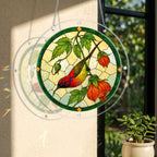 Round stained-glass-style red songbird and falling leaf puzzle suncatcher hanging in natural window light