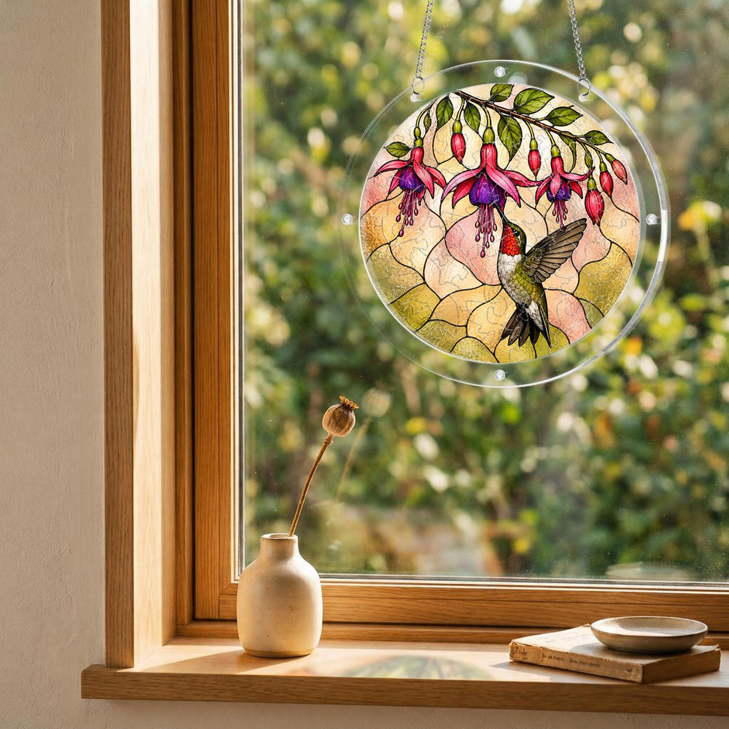 Round hummingbird and pink fuchsia puzzle suncatcher hanging in a cozy indoor window with soft sunlight