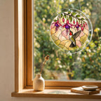 Round hummingbird and pink fuchsia puzzle suncatcher hanging in a cozy indoor window with soft sunlight