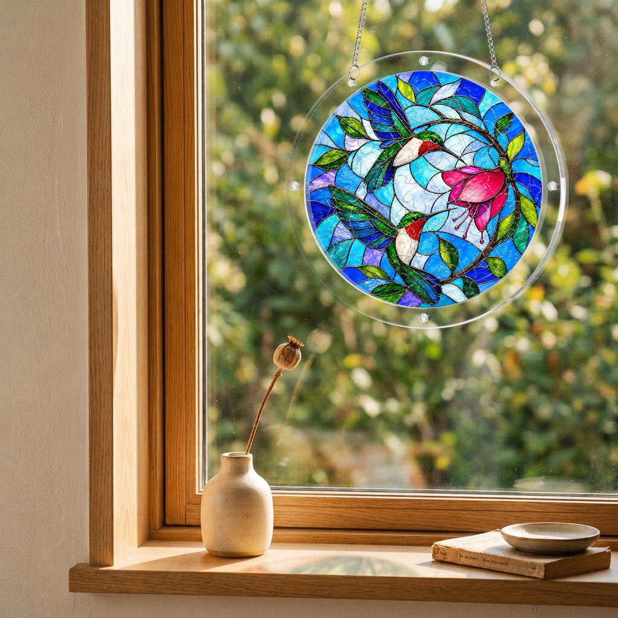 Round hummingbird and pink flower puzzle suncatcher hanging in a cozy indoor window with soft daylight