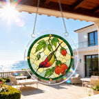 Red songbird and autumn leaf puzzle suncatcher hanging on an outdoor patio window in bright daylight
