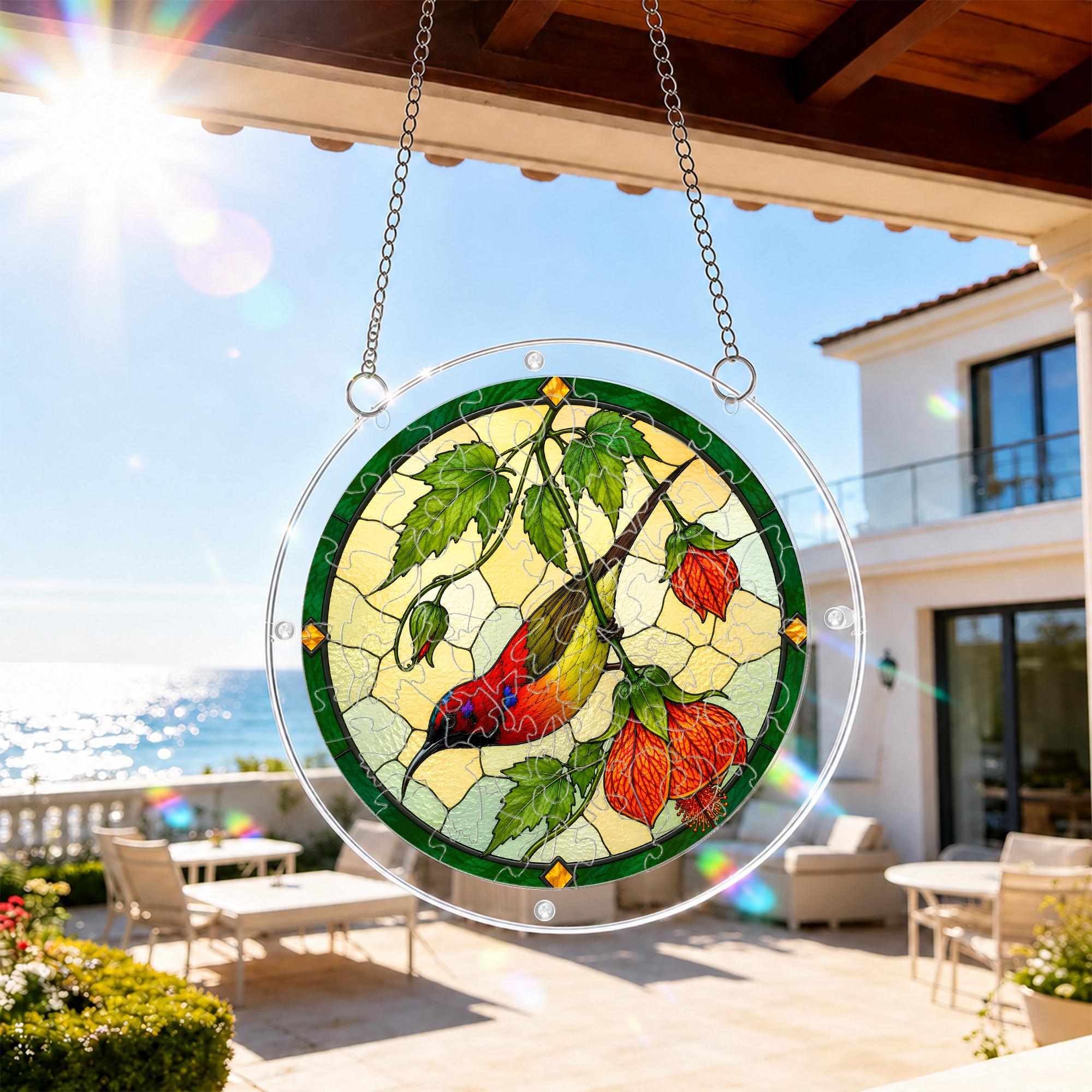 Red songbird and autumn leaf puzzle suncatcher hanging on an outdoor patio window in bright daylight