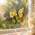 Colorful butterfly yellow rose broken-glass hologram acrylic suncatcher hanging on a sunny window with crystal prism and garden view