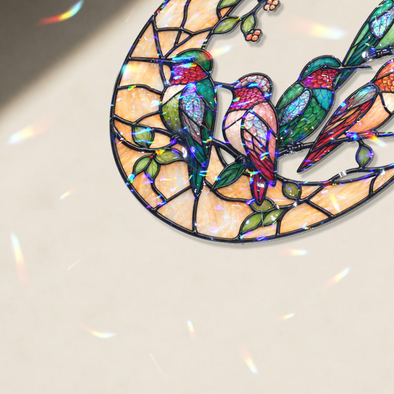 Close-up of colorful hummingbirds perched on a stained-glass-inspired crescent moon holographic acrylic suncatcher.