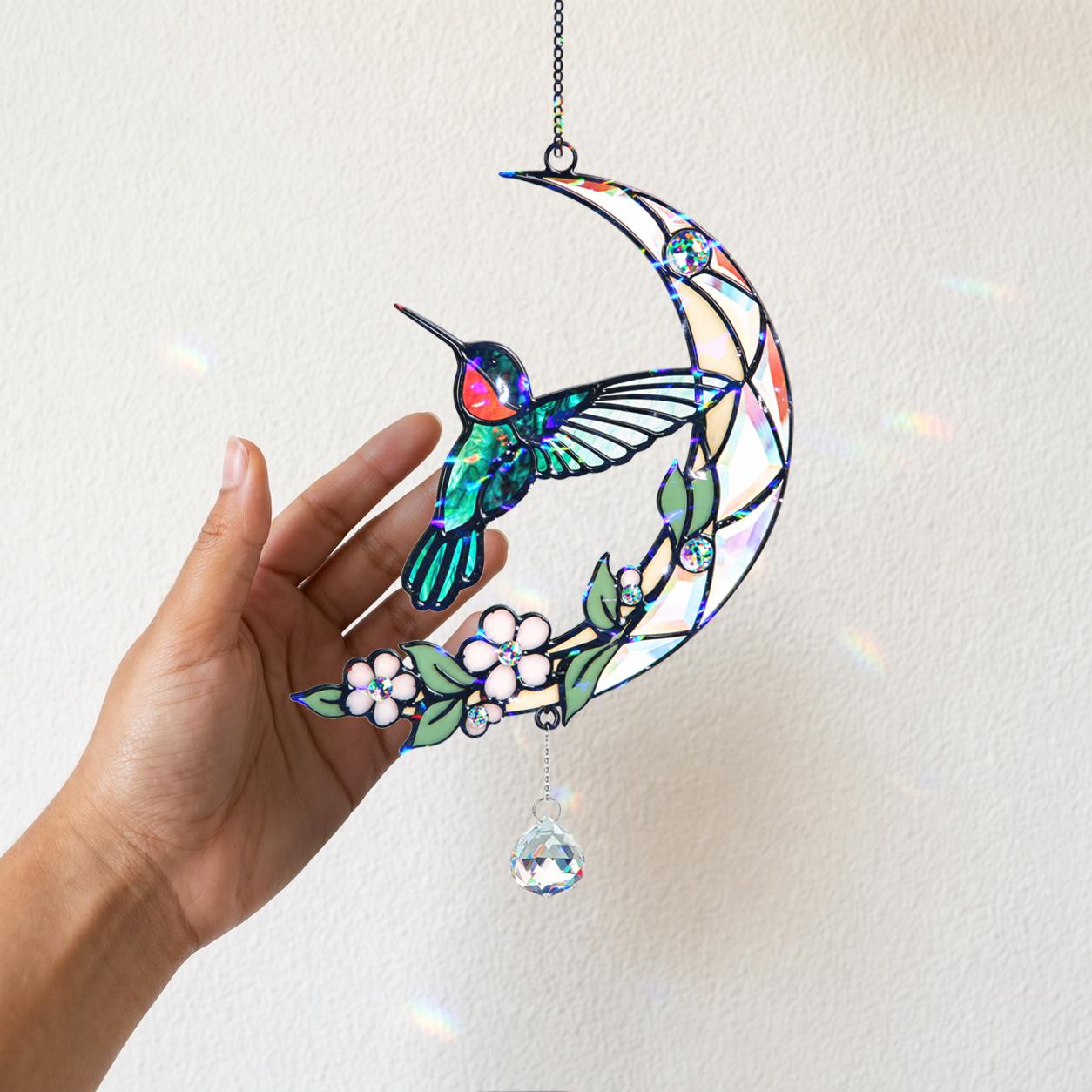 Hand holding the hummingbird moon blossom acrylic suncatcher to highlight its colorful holographic broken glass finish.