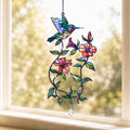 Hummingbird blooming vine holographic acrylic suncatcher hanging on a sunny window with soft light and crystal charm
