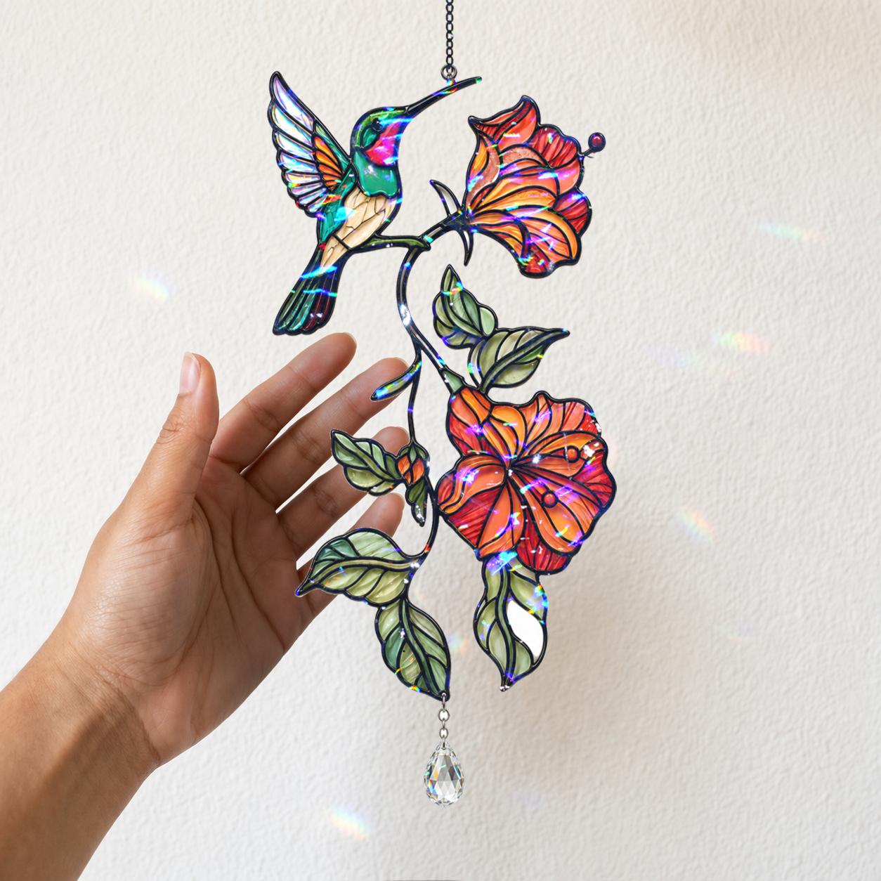 Close up of a hand holding a hummingbird hibiscus holographic acrylic suncatcher with crystal charm