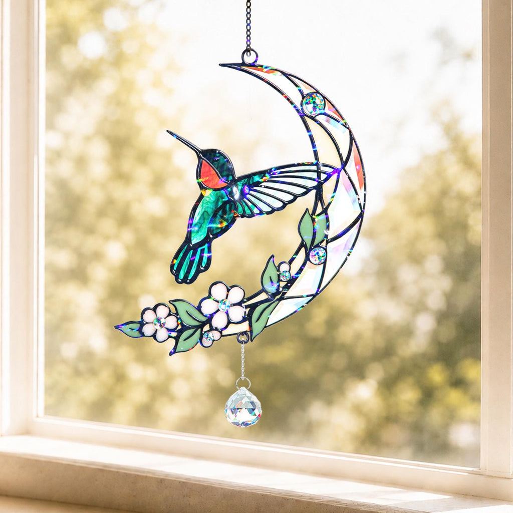 Hummingbird moon blossom holographic acrylic suncatcher hanging on a sunny window with soft natural light