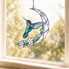 Hummingbird moon blossom holographic acrylic suncatcher hanging on a sunny window with soft natural light