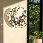 Hummingbird moon holographic acrylic suncatcher hanging on a bright window near soft pink flowers
