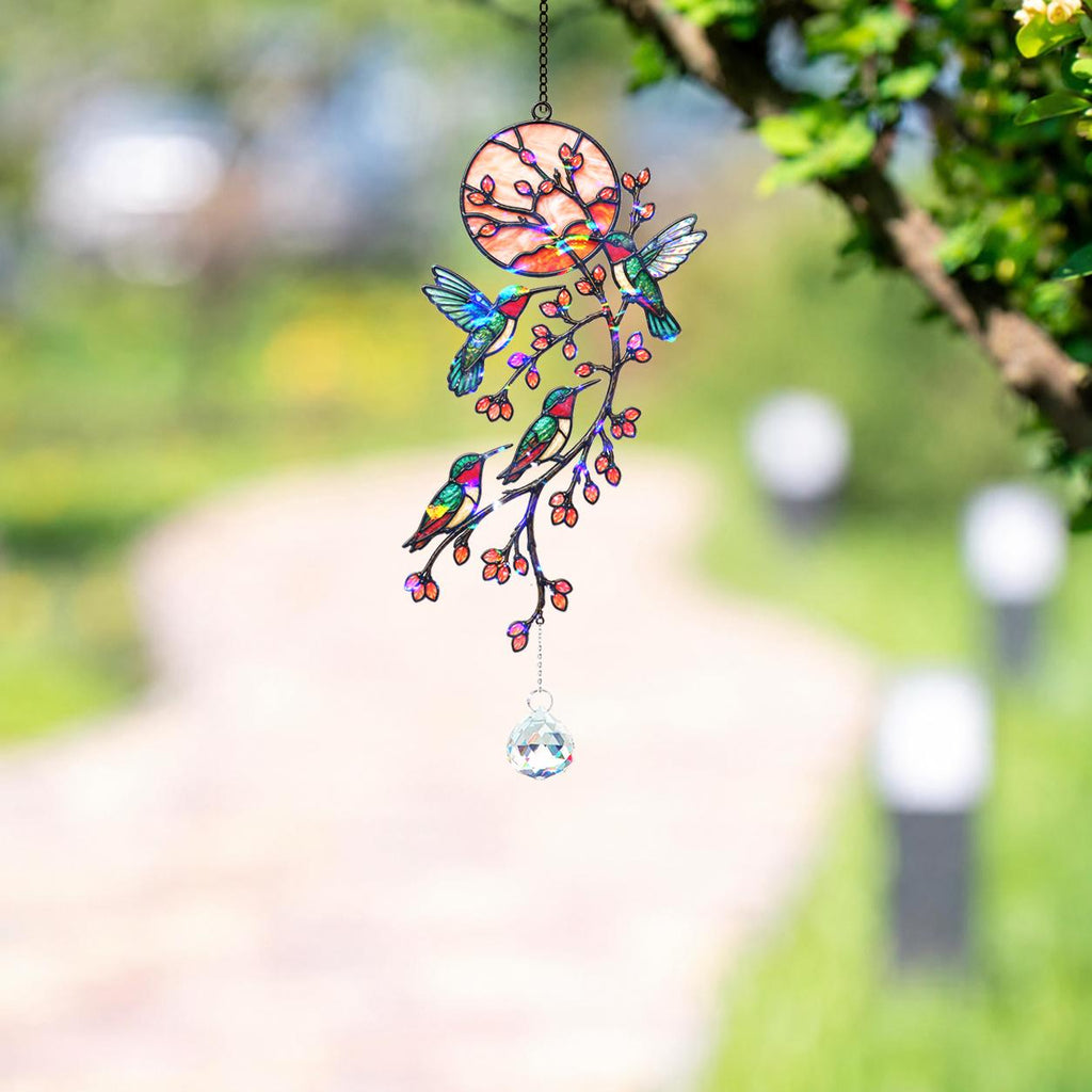 Hummingbird holographic acrylic suncatcher hanging outdoors with blooming branch design and crystal charm