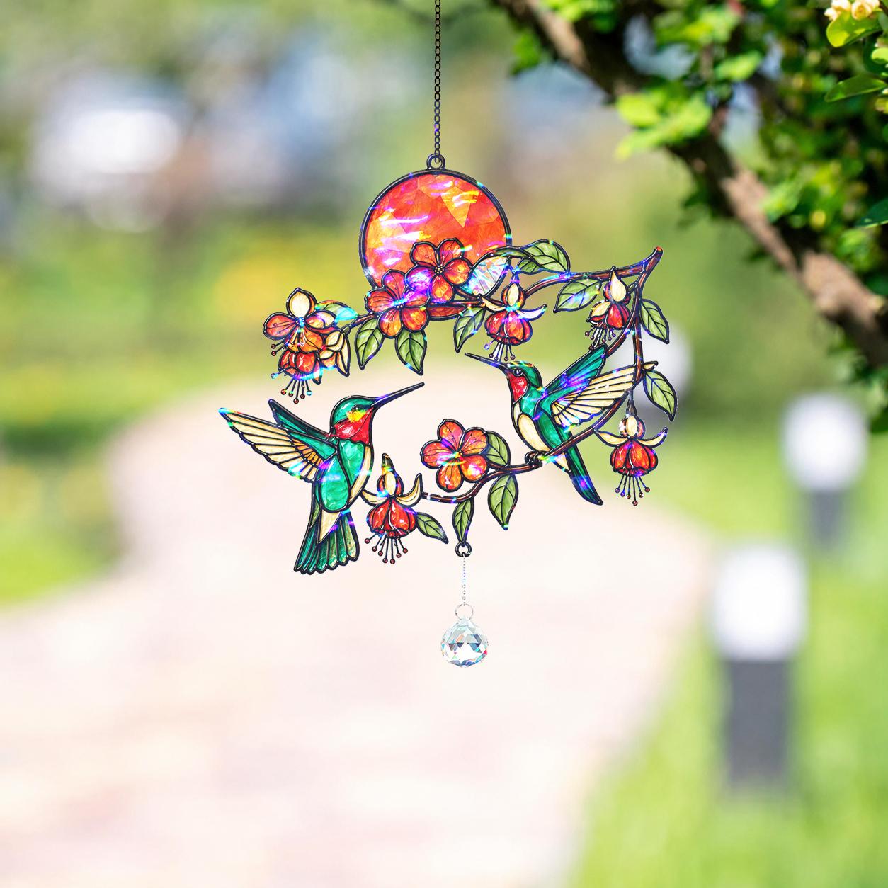 Hummingbird fuchsia sunset holographic acrylic suncatcher hanging in a green garden setting
