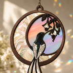 Hanging Hummingbird Crescent Moon suncatcher close-up in a bright, airy living room window, rainbow light reflections on walls, warm sunlight, and subtle indoor decor.