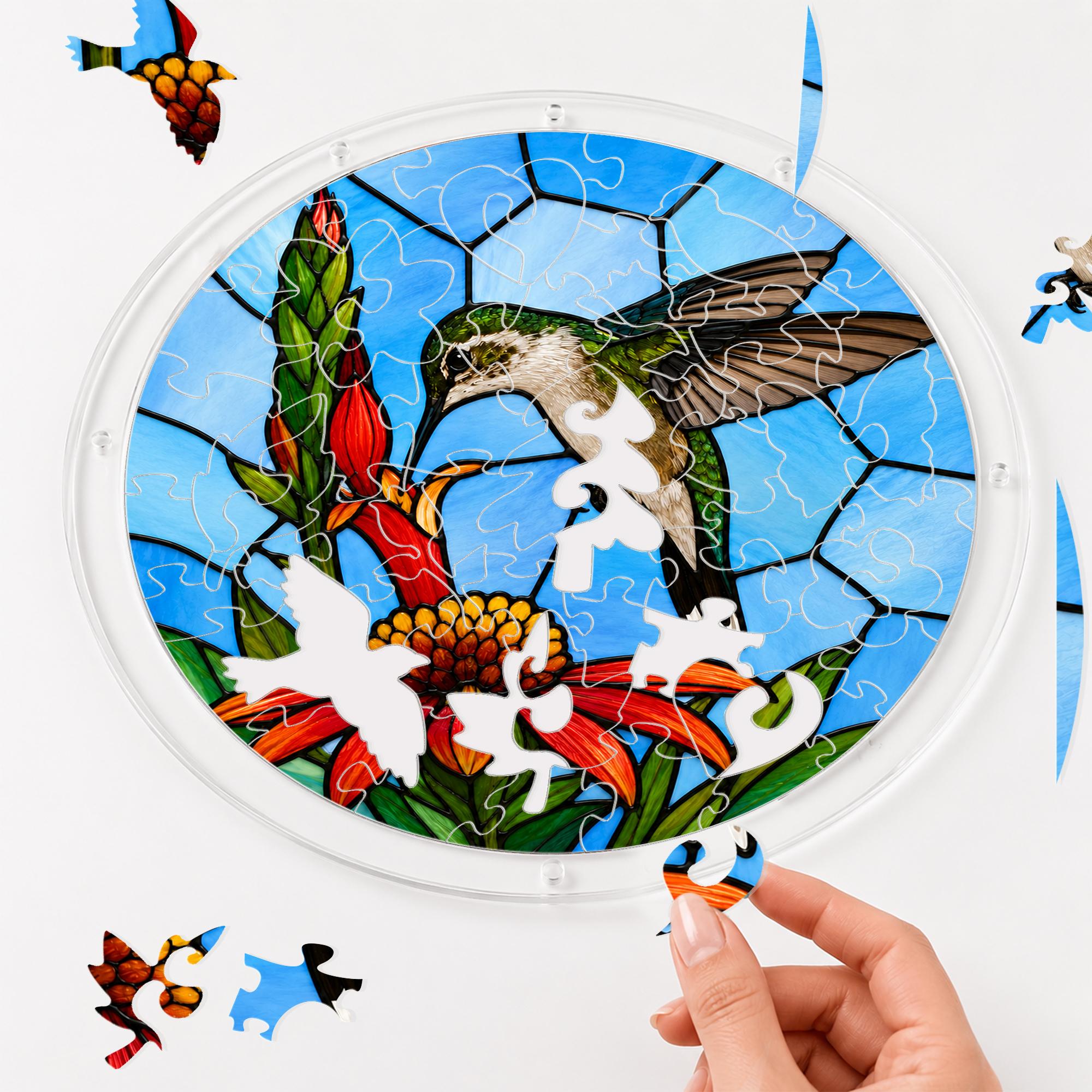 Hands assembling a round hummingbird tropical flower acrylic jigsaw puzzle suncatcher with colorful interlocking pieces