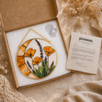 Decorative floral design in a box with 'pixiwoo' storytelling card on a textured surface