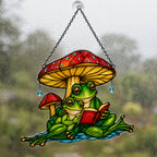 Close view of the frog couple mushroom umbrella suncatcher on a rainy window pane