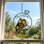 Personalized frog wedding couple suncatcher hanging in a bright window under a blue sky