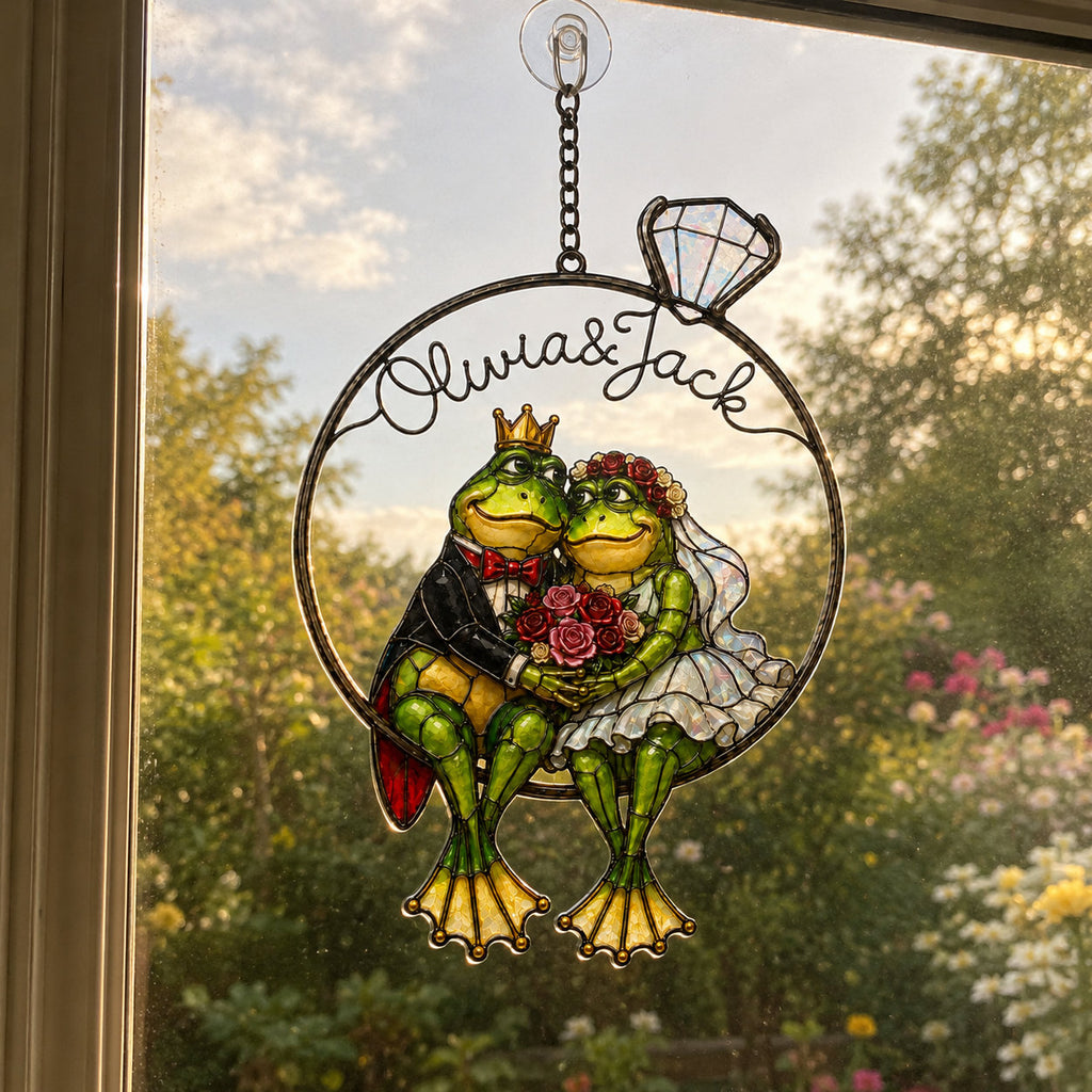 Frog wedding couple ring suncatcher in a sunrise window with a flowering garden behind