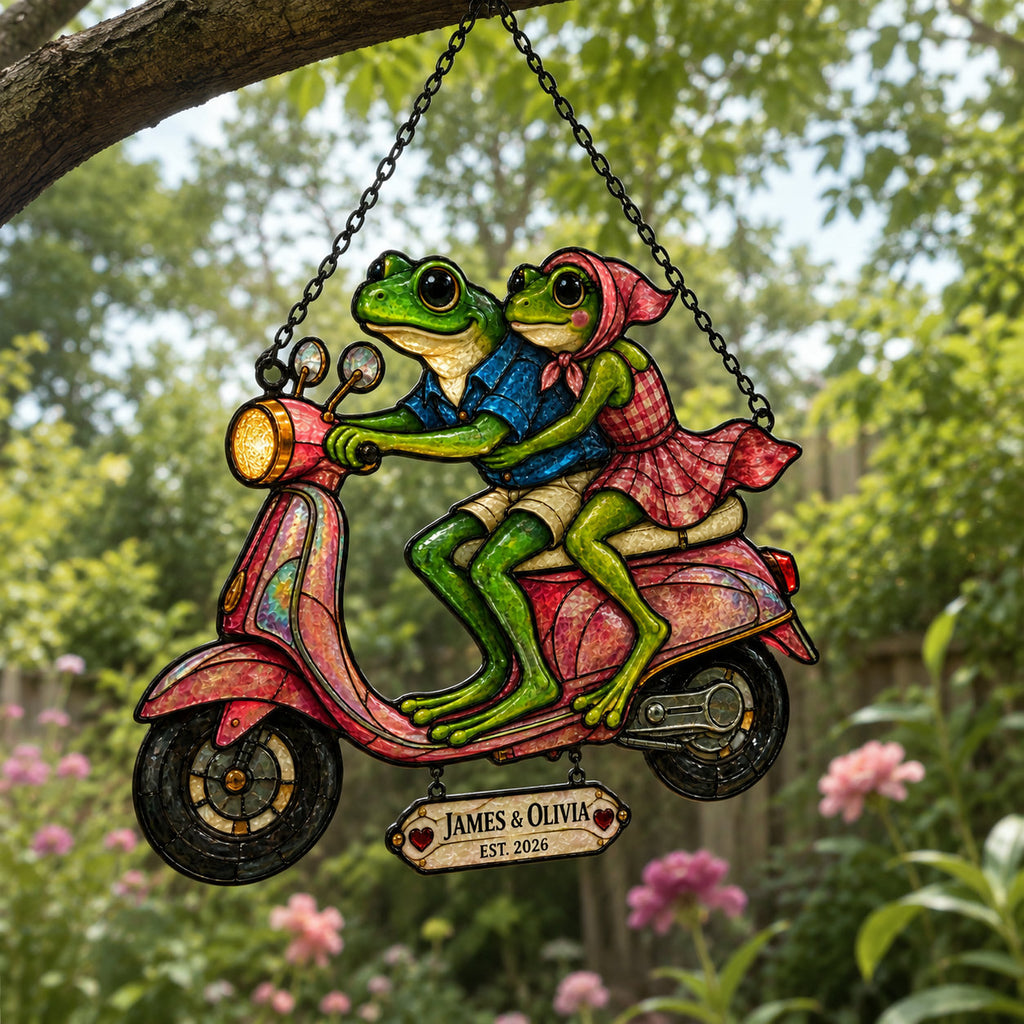 Personalized frog couple scooter suncatcher hanging outdoors among garden flowers