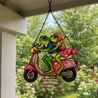 Personalized frog couple scooter suncatcher hanging on a covered porch