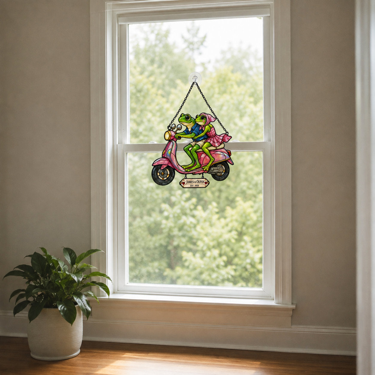 Personalized frog couple scooter suncatcher seen from a living room window