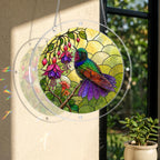Round stained glass style hummingbird fuchsia suncatcher hanging on a window with warm natural sunlight