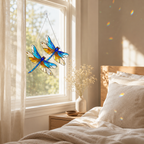 Double Dragonfly holographic acrylic suncatcher hanging near a bedroom window, casting soft rainbow reflections in warm morning light.