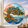 Stained glass panel with a tree design hanging by a window with a scenic view.