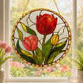 Stained glass panel with red, pink, and yellow tulips hanging on a window.