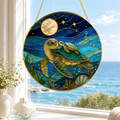 Stained glass panel with two turtles swimming underwater, hanging by a window with a view of the ocean.