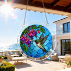 Hummingbird fuchsia acrylic puzzle suncatcher hanging on an outdoor patio window in bright sunlight