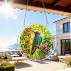 Hummingbird floral acrylic puzzle suncatcher hanging on an outdoor patio window in bright daylight