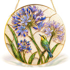 Blue agapanthus bird gold frame suncatcher in a sunny window