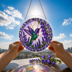 Purple floral hummingbird acrylic puzzle suncatcher held up against a bright blue sky and garden background.