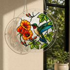 Blue wing hummingbird orange flower acrylic puzzle suncatcher displayed in sunlight near a window