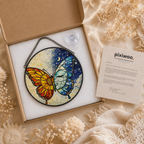 Stained glass butterfly artwork in a box with 'pixiwoo' documentation, surrounded by dried flowers.