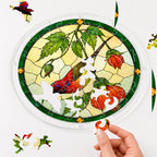 Hand assembling a cardinal orange lantern flower acrylic puzzle suncatcher with colorful puzzle pieces