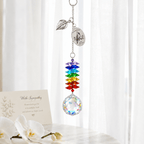 Personalized cardinal memorial crystal suncatcher hanging in front of sheer curtains with remembrance card and soft white flowers