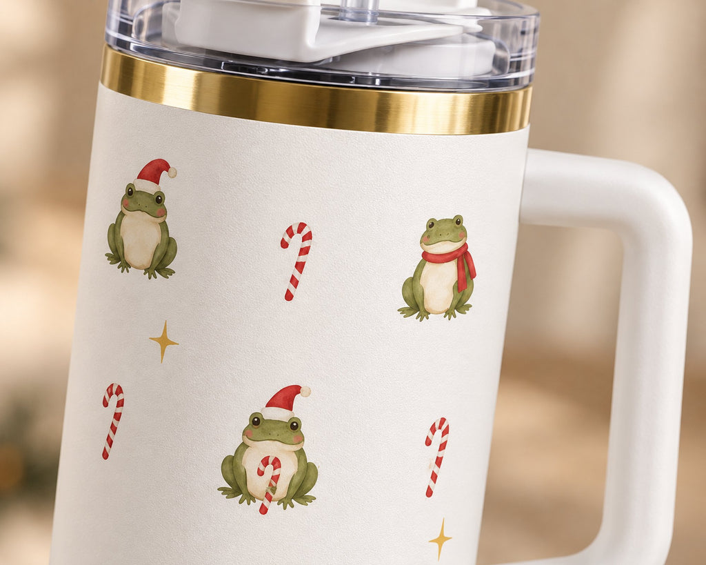Close-up of the watercolor frogs in Santa hats and red scarves, one hugging a candy cane