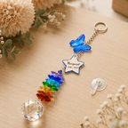 Personalized memorial butterfly crystal suncatcher displayed on wooden tabletop with blue butterfly charm, custom star charm, rainbow crystal strand, and clear crystal ball