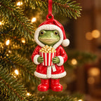 Santa Popcorn frog ceramic ornament: frog in a red Santa robe holding a striped popcorn tub, hanging on a Christmas tree